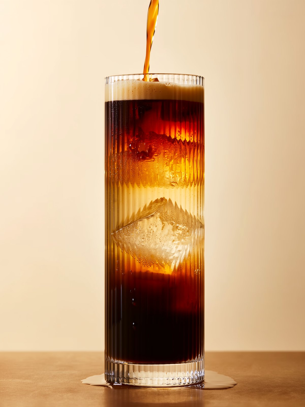 Espresso Tonic im Glas: dunkler Cold Brew sinkt sichtbar durch helles Tonic über Eis