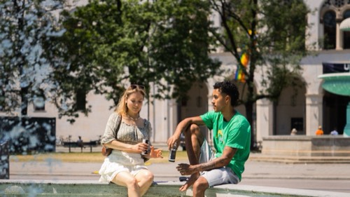 Paar mit Espresso Tonic, Füße im Brunnen, Querformat